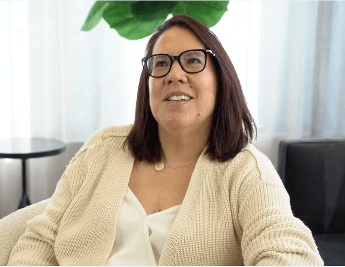 Woman in white sweater smiling at the camera
