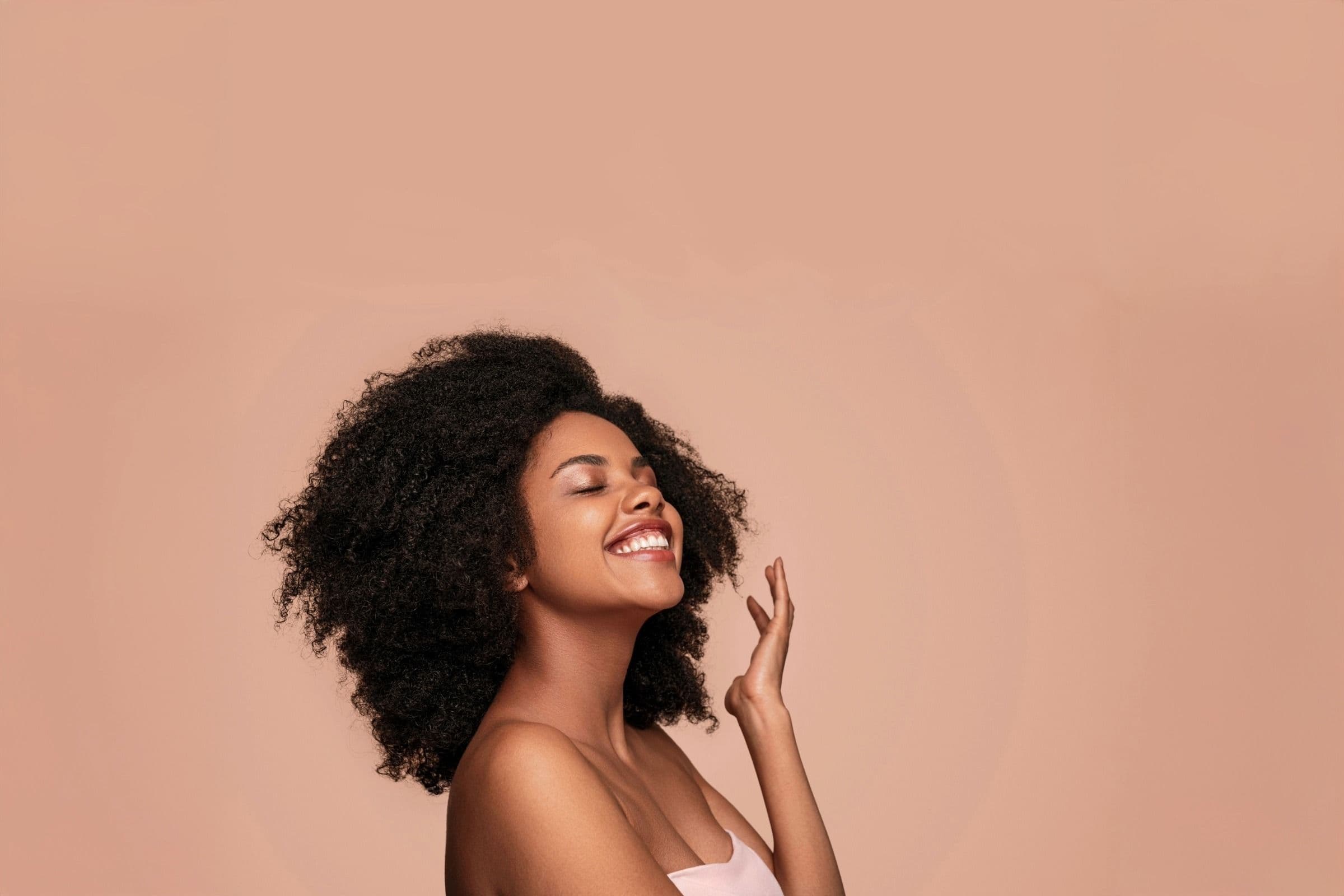 NAD+ Therapy at Revive Med Spa. Woman with curly hair and glowing skin smiling