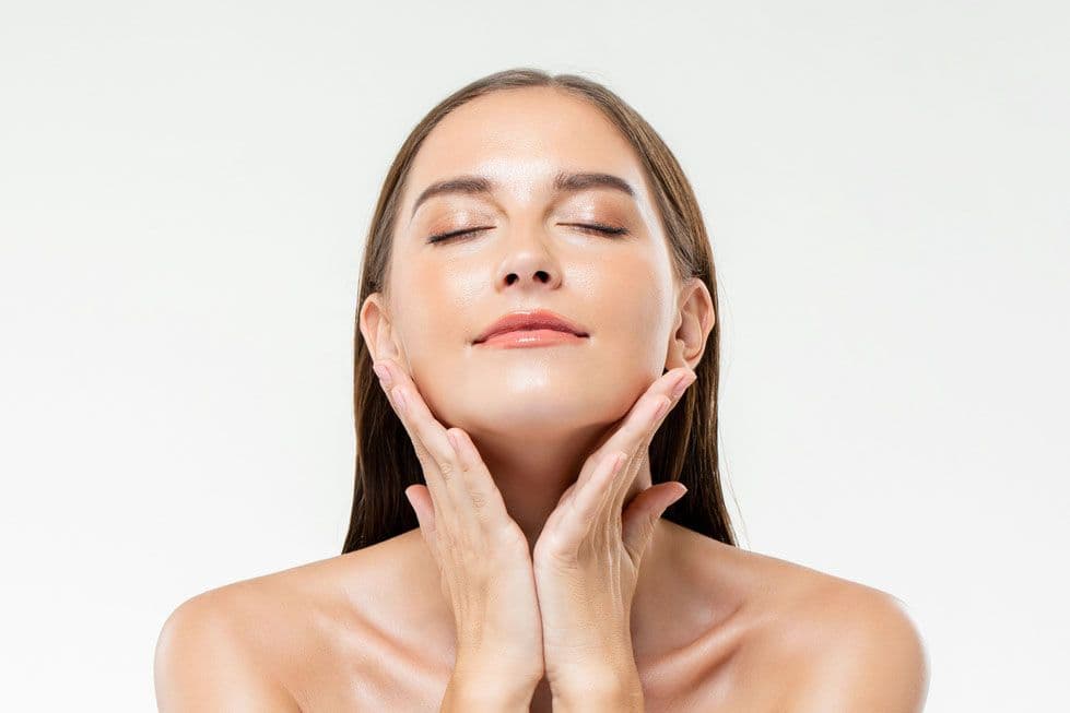 Woman with glowing skin and eyes closed after salmon DNA PRDN treatment