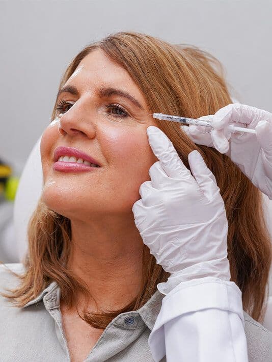 Woman receiving injection on her face