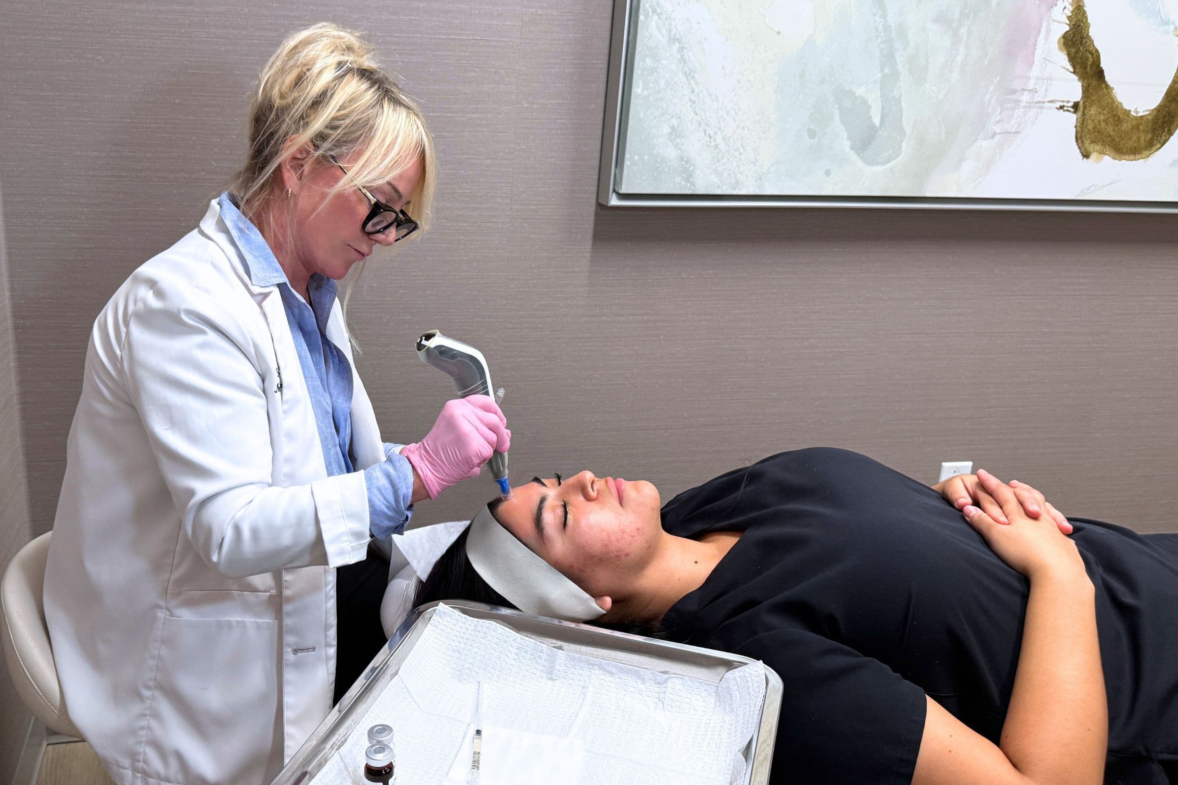 Provider administering mesotherapy mesoneedling treatment to a woman
